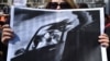 KYRGYZSTAN -- A woman holds a picture as she attends a rally for women's rights protection in Bishkek, April 8, 2021